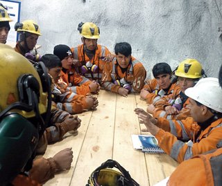 Operadores de equipo pesado de Morococha recibiendo capacitación del supervisor de mantenimiento.